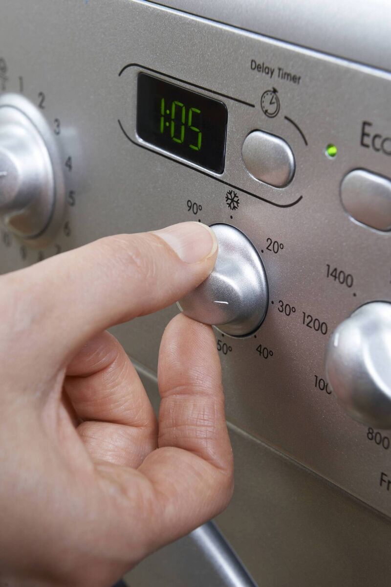 Someone changing the temperature on their washing machine. PA