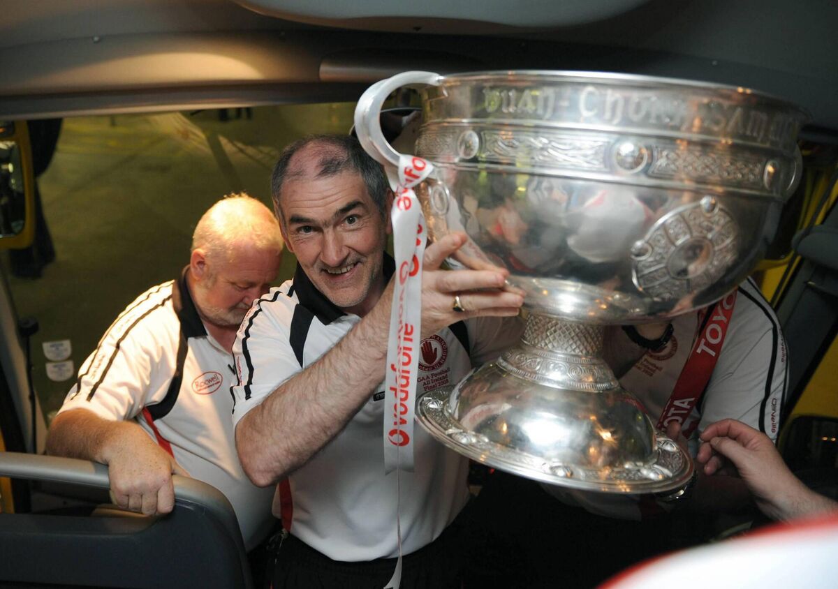 Tyrone manager Mickey Harte brings the Sam Maguire cup onto the bus. Picture: Stephen McCarthy / Sportsfile