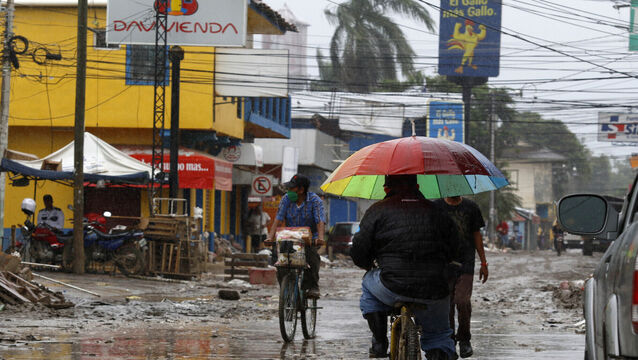 Locals move on street barely cleared from the debris of the last storm, before Hurricane Iota makes landfall in La Lima, Honduras (Delmer Martinez/AP)