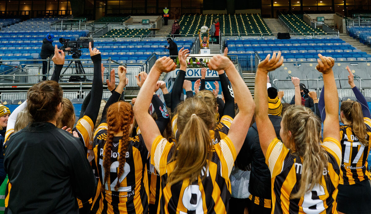 Kilkenny players celebrate as team mates lift the trophy. Picture: INPHO/James Crombie