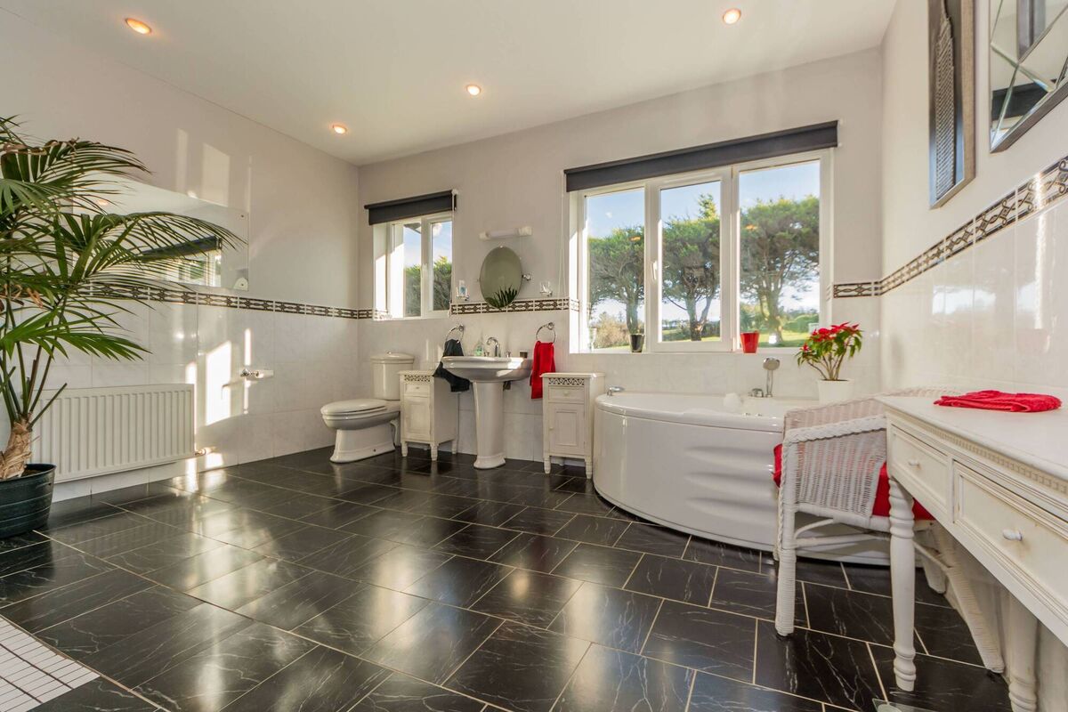 The bathroom has glazed tiles, a Jacuzzi bath and wet-room style shower