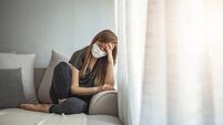 Sad lonely girl isolated stay at home in protective sterile medical mask on face looking at window