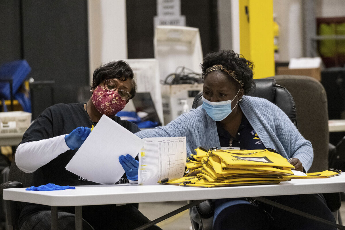 Elections workers at the Fulton County Georgia elections warehouse check in voting machine memory cards that store ballots following the Senate runoff election in Atlanta on Tuesday. Picture: AP Photo/Ben Gray