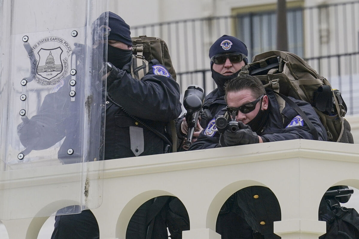 Police keep a watch on demonstrators who tried to break through a police barrier. (AP Photo/John Minchillo)