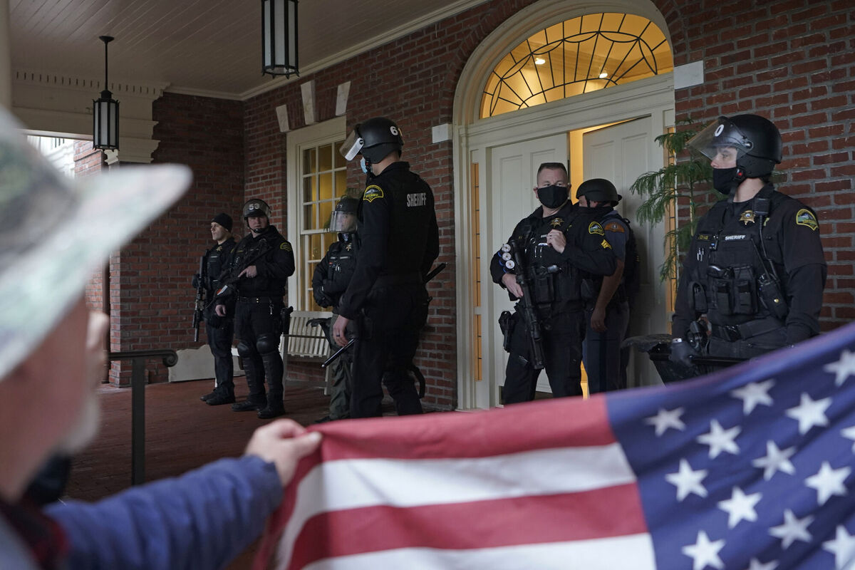 Protesters square off with law enforcement officers on the front porch of the Governor's Mansion after a group of people got through a perimeter fence. Picture: AP Photo/Ted S. Warren