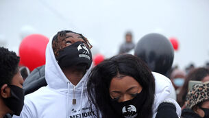 Emmanuel and Gloria, George Nkencho’s brother and sister, alongside family and friends who gathered to release balloons (Niall Carson/PA)