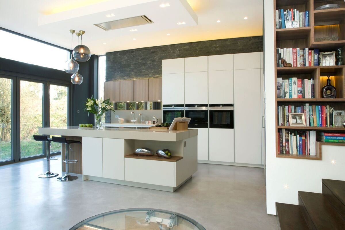 Cabinets in the island here include cutouts for display and dining. A change in materials and downlighting updates hanging cabinets on the wet side of the rear left wall, Pogenpohl.