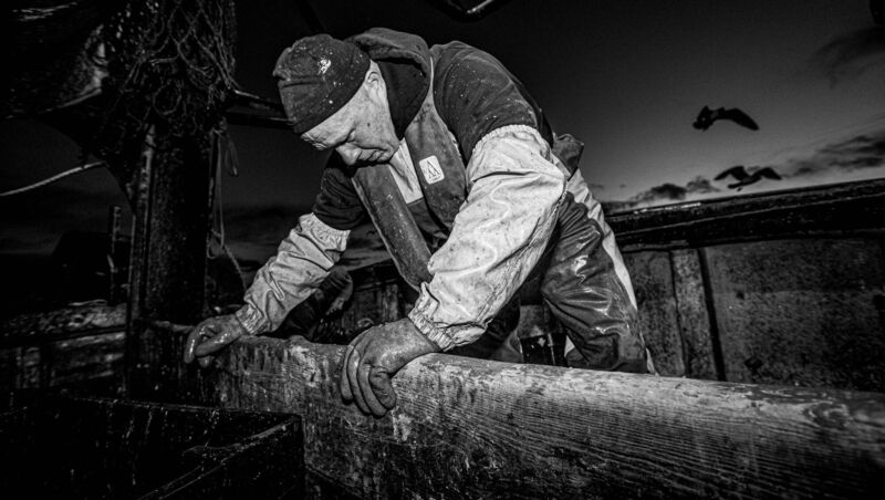 A brief moment of respite while sorting out the catch: Egidijus Maciulskis is one of the trawlermen working late into the evening of December 31, 2020, on board La Petite Edelweiss which operates out of Castletownbere in Bantry Bay, West Cork. 	Picture: Neil Michael