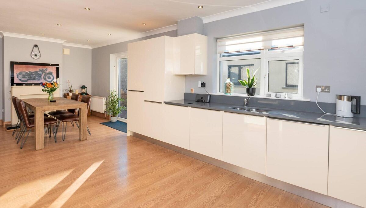The full-width kitchen at 23 Kiltegan Park has  integrated Bosch appliances, spacious dining area, Silestone fireplace, and French doors to the back patio. 	Pictures: John Roche