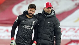 <p>Liverpool goalkeeper Alisson is pulled away by his manager Jurgen Klopp as he speaks to the officials after the match at Anfield. Picture: PA</p>