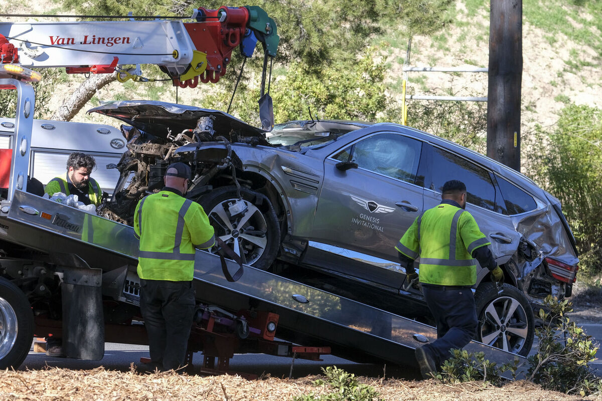 A damaged vehicle is placed on a flatbed truck following a rollover accident involving golfer Tiger Woods, Tuesday, Feb. 23, 2021, in the Rancho Palos Verdes suburb of Los Angeles. Woods suffered leg injuries in the one-car accident and was undergoing surgery, authorities and his manager said. (AP Photo/Ringo H.W. Chiu)