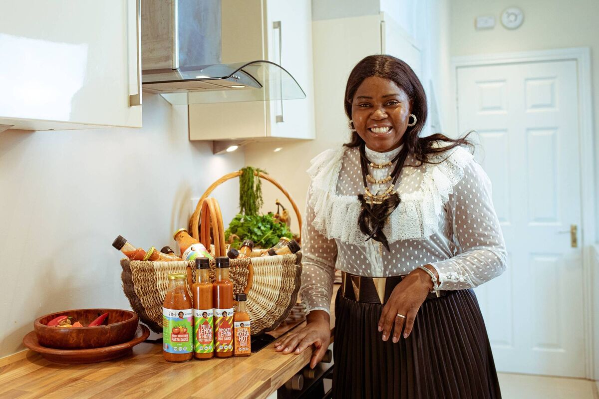 Ellie Kisyombe, posing next to a selection of her signature sauces.