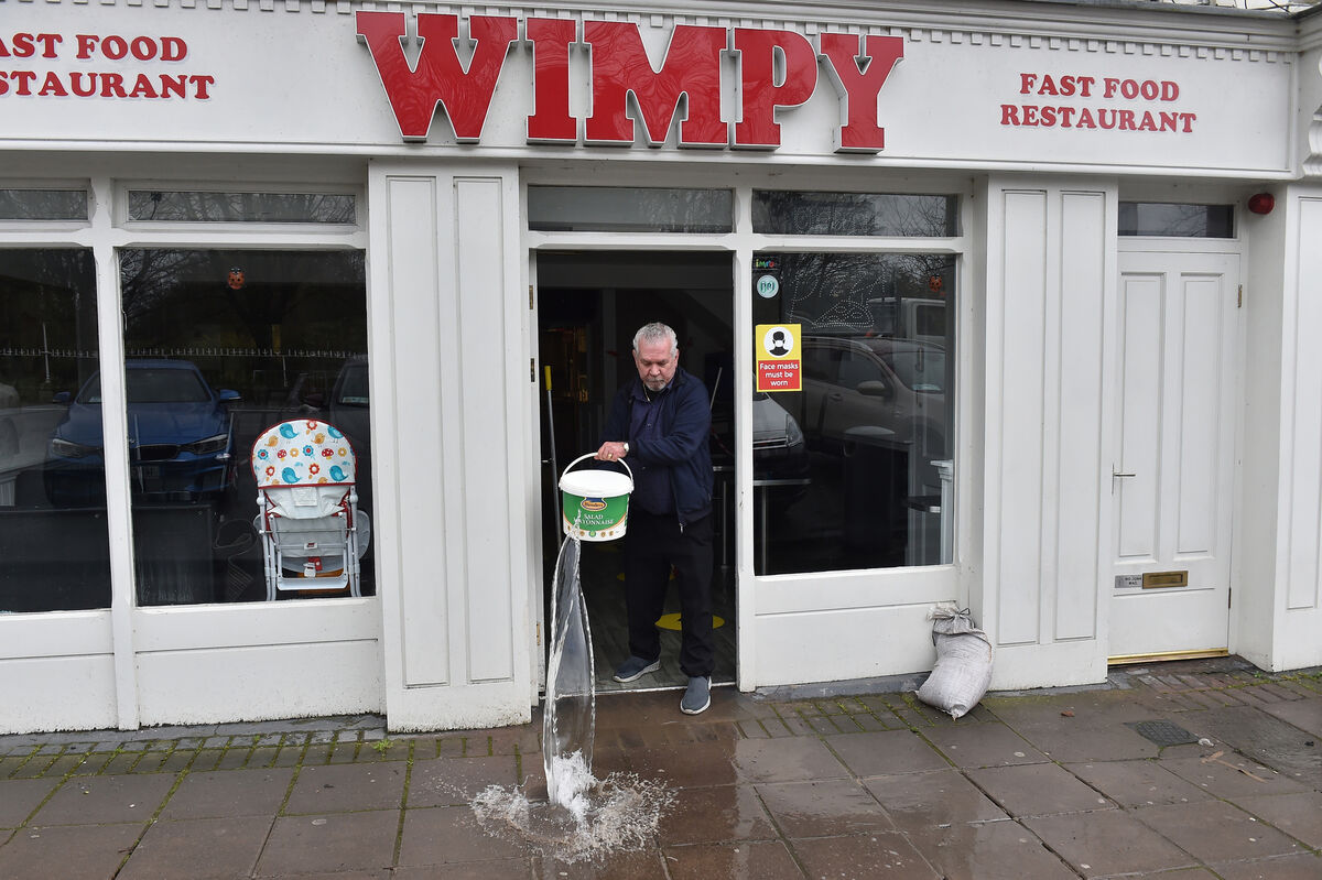  Antonio Talossi throws out a bucket of floodwater from his restaurant on Brian Boru Square in Fermoy, which was hit by flooding in February. Picture: Dan Linehan