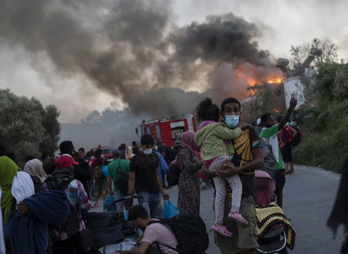 Migrants flee from the fire in Moria refugee camp. Picture: AP Photo/Petros Giannakouris
