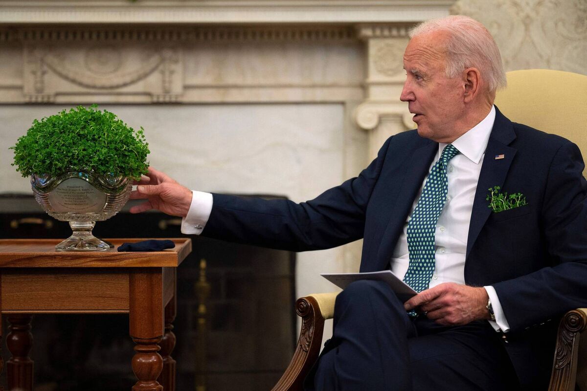 US President Joe Biden looks at the bowl of shamrock at the White House. He is looking forward to visiting Ireland, Mr Martin said. Picture: Jim Watson 