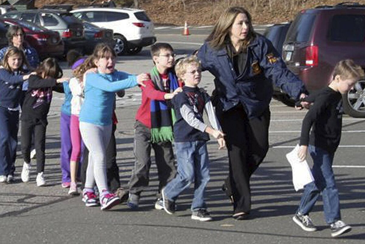 Connecticut State Police lead children from the Sandy Hook Elementary School in Newtown, Conn., following the shooting on Friday, December 14, 2012. Picture: AP Photo/Newtown Bee, Shannon Hicks Connecticut State Police lead children from the Sandy Hook Elementary School in Newtown, Conn., following the shooting on Friday, December 14, 2012. Picture: AP Photo/Newtown Bee, Shannon Hicks