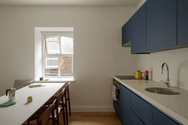 Kitchen units have pops of flat colour and narrow tables have been installed to work with space limitations. Kitchen units have pops of flat colour and narrow tables have been installed to work with space limitations.