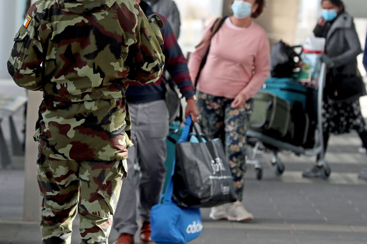 A member of the defence forces directs passengers arriving at Dublin Airport from one of 33 high risk countries who will be transported to a mandatory 12-day hotel quarantine. Picture: Brian Lawless/PA Wire