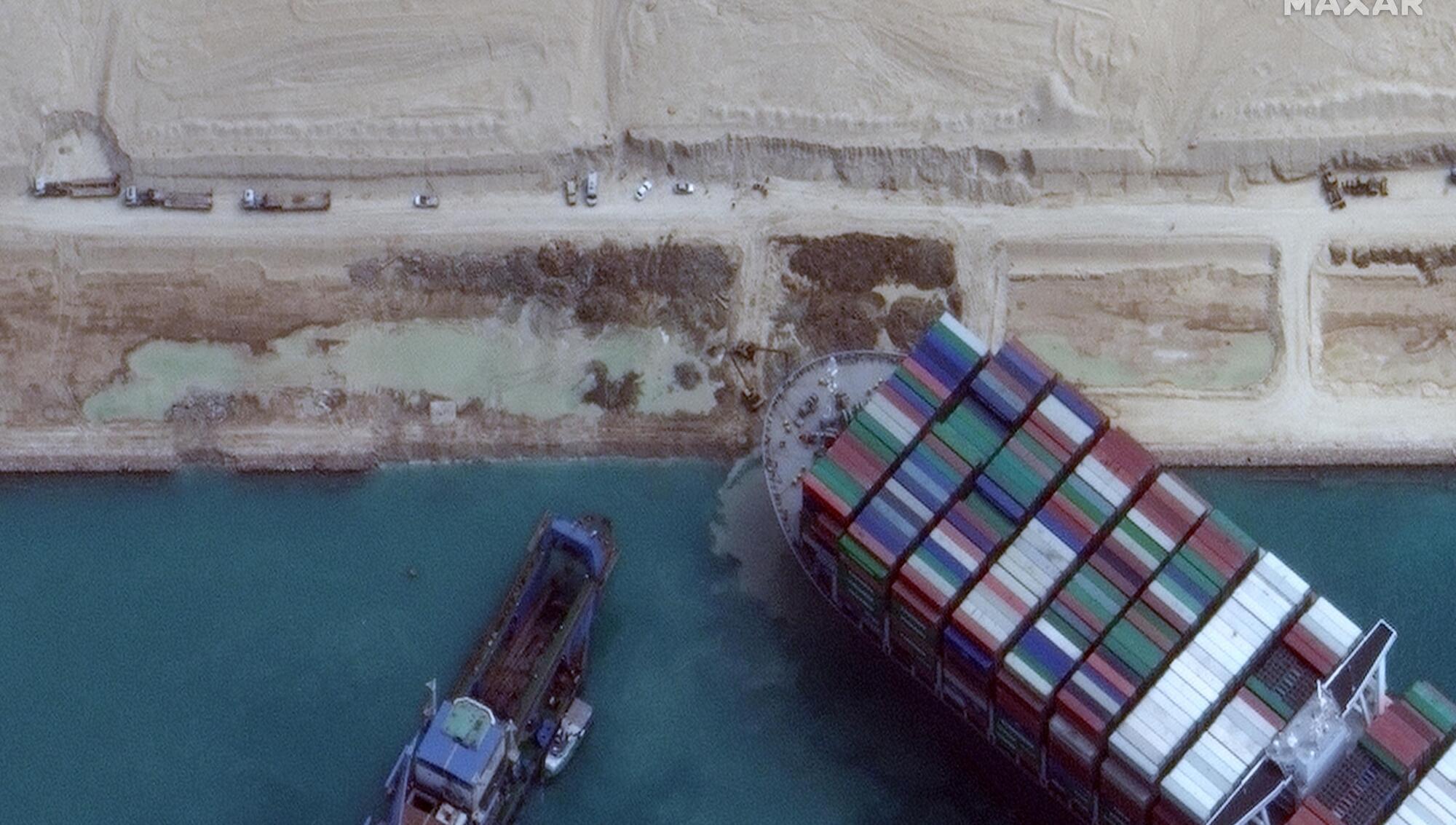 Workers free stricken container ship which was stuck across Suez Canal