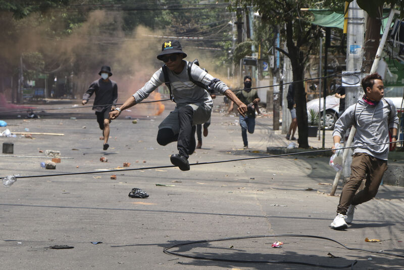 Anti-coup protesters run to avoid military forces during a demonstration in Yangon, Myanmar. Anti-coup protesters run to avoid military forces during a demonstration in Yangon, Myanmar.