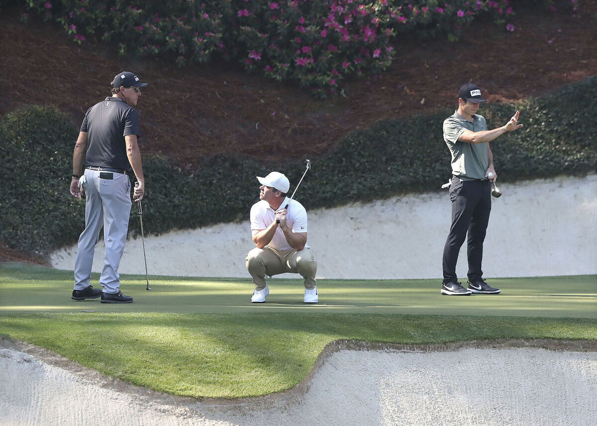Phil Mickelson (from left) looks on as Paul Casey reacts to just missing his birdie putt while Viktor Hovland lines his putt up on the 12th green during their practice round for the Masters at Augusta National. (Curtis Compton/Atlanta Journal-Constitution via AP)