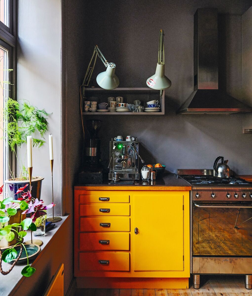 The sombre grey walls in this galley kitchen is given a burst of colour on the surface of a retro cabinet. The sombre grey walls in this galley kitchen is given a burst of colour on the surface of a retro cabinet.