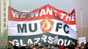 <p>Fans hold up a banner as they protest against the Glazer family, owners of Manchester United, before the postponed Premier League match against Liverpool</p>