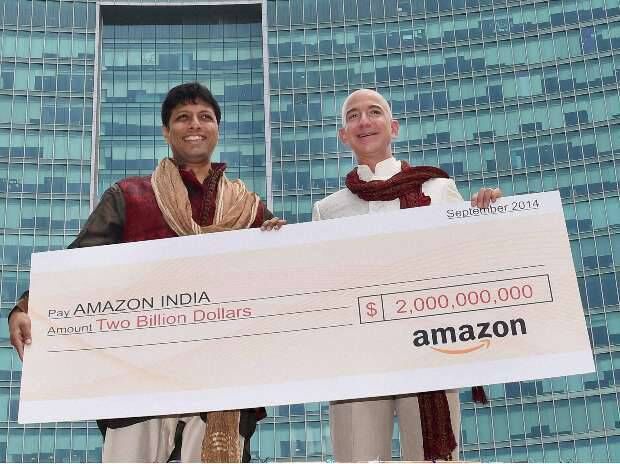 Jeff Bezos on top of a truck flashing a big $2-billion cheque in Bangalore. Jeff Bezos on top of a truck flashing a big $2-billion cheque in Bangalore.