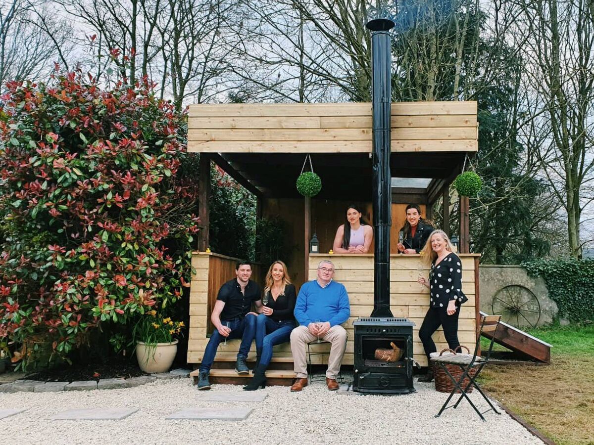 Bernard Deay and his family with the upcycled hot tub relaxation area he created.