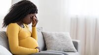 Young pregnant black woman suffering from headache or migraine