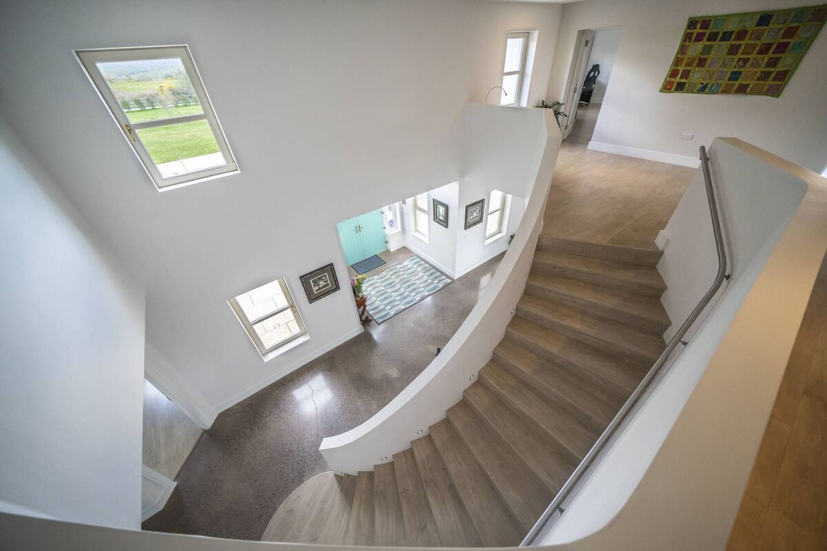 The gracious curve of the home's centerpiece staircase, in the double-height entrance hall.