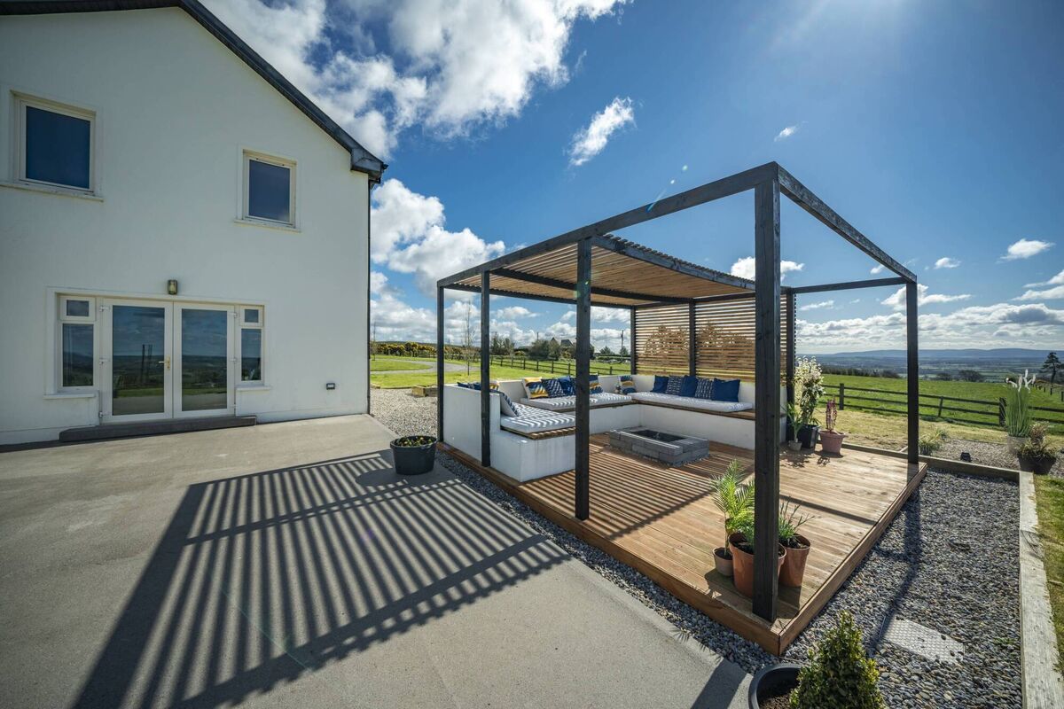 Australian-style contemporary pergola and seating bower on the rear terrace.