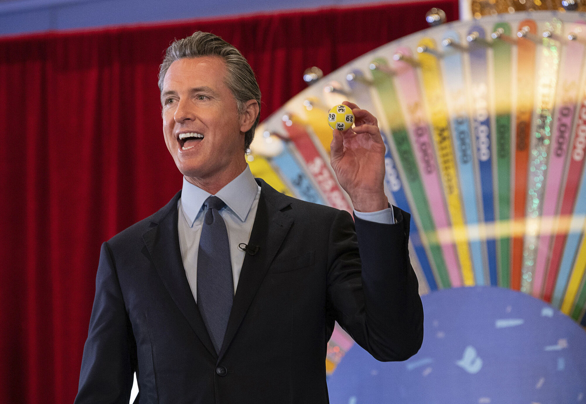 California Gov. Gavin Newsom holds up a lottery ball at the California Lottery Headquarters on Friday in Sacramento, Calif., while drawing numbers for California's new vaccine incentive program. Picture: Paul Kitagaki Jr./The Sacramento Bee via AP