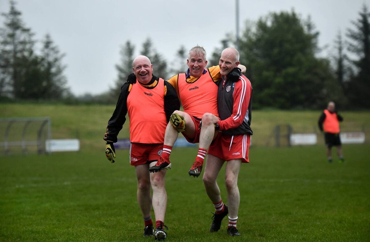 Paulinus Curran is carried off the field after sustaining an injury by Seamus McMahon, left, and Ciaran McMahon at the GAA for Dads &amp; Lads launch at St Patricks GFC in Donagh, Fermanagh. Picture: David Fitzgerald/Sportsfile