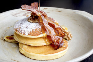 American buttermilk pancakes with crispy bacon and maple syrup
