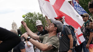 <p>A man throws a tennis ball during an anti-lockdown protest in central London (Aaron Chown/PA)</p>