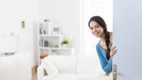 Cheerful woman inviting people to enter in home