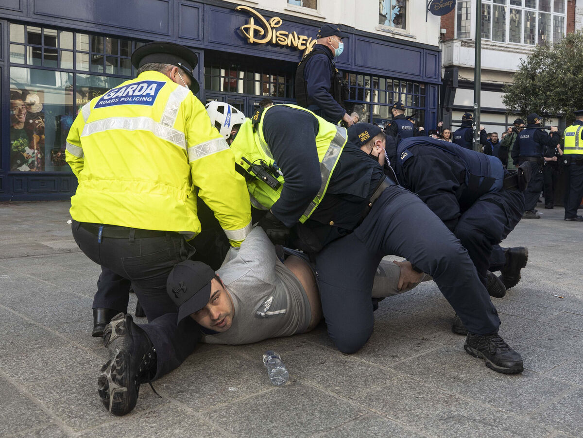 Gardai restrain a protester during the February anti-lockdown protest in Dublin city centre. PA Photo. 