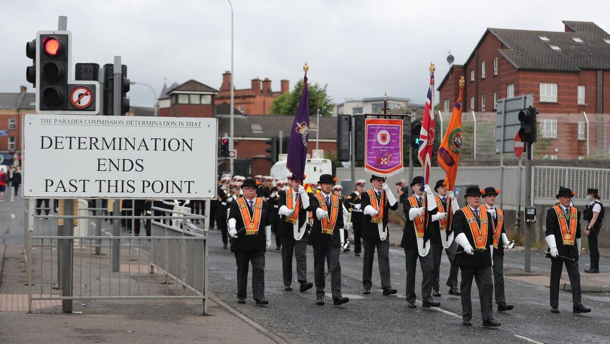 Orangemen march past a Parades Commission sign which prevents them from playing music in the Clifton Street area of Belfast. Picture: Niall Carson/PA Wire