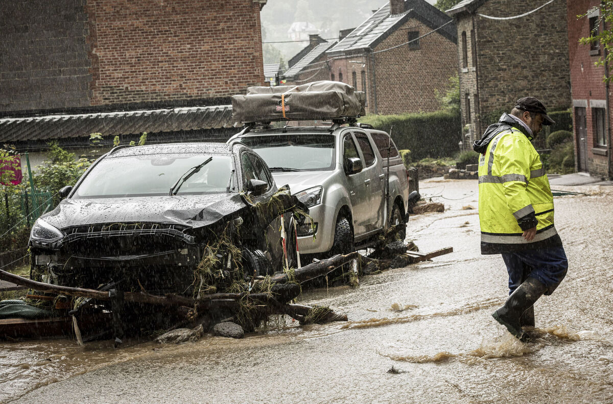 A man walks by damaged cars in a flooded street in Mery, Province of Liege, Belgium. Picture: AP Photo/Valentin Bianchi) A man walks by damaged cars in a flooded street in Mery, Province of Liege, Belgium. Picture: AP Photo/Valentin Bianchi)