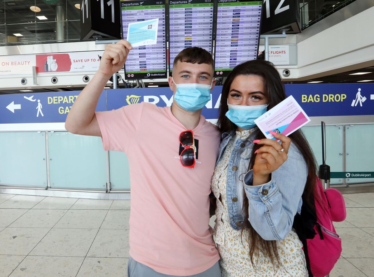 Dylan Gilhooly and Leah O'Driscoll wearing face masks and holding their Covid Vaccine certs in Dublin Airport so they can travel to Lanzarote. Picture: Sasko Lazarov/ RollingNews.ie