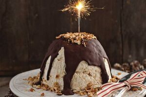Frosted meringue Christmas pudding with chocolate sauce and toasted hazelnuts