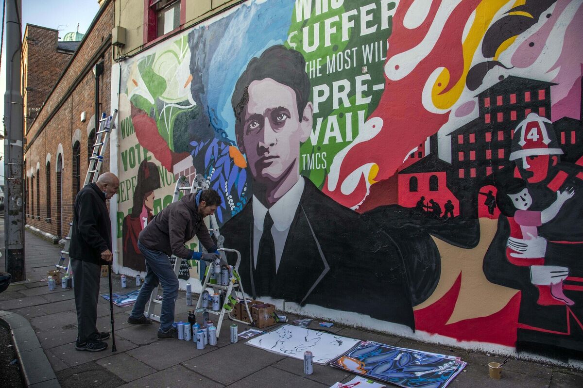 A man stops to look at artist Garreth Joyce at work on his mural titled 'Those who suffer the most will prevail'. Picture: Clare Keogh A man stops to look at artist Garreth Joyce at work on his mural titled 'Those who suffer the most will prevail'. Picture: Clare Keogh