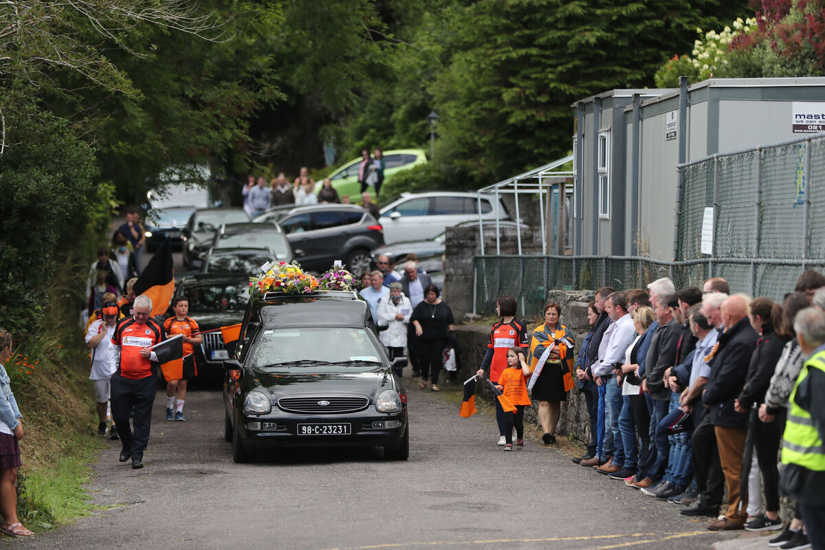 Members of St Colum's GAA club line up as the coffin of Father Con Cronin is taken from St Joseph's Church, Coomhola, Co Cork, following his funeral. Picture: Niall Carson/PA Wire