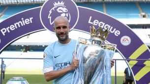 <p>Manchester City manager Pep Guardiola celebrates with the Premier League trophy</p>