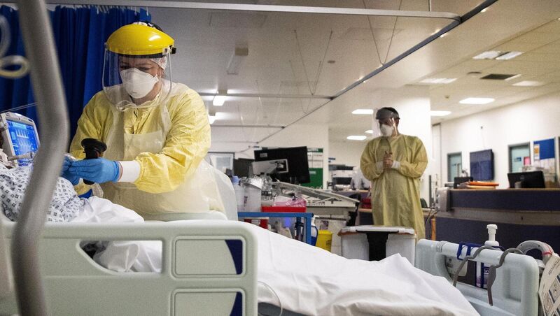 A nurse works on a patient in an ICU A nurse works on a patient in an ICU