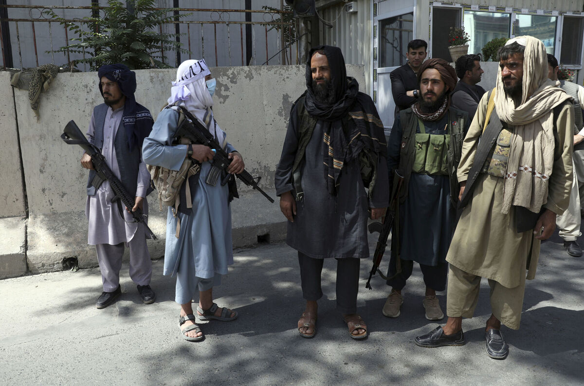 Taliban fighters stand guard at the main gate leading to the Afghan presidential palace, in Kabul, yesterday. The streets of Kabul were emptied of women that day. Photo: AP/Rahmat Gul