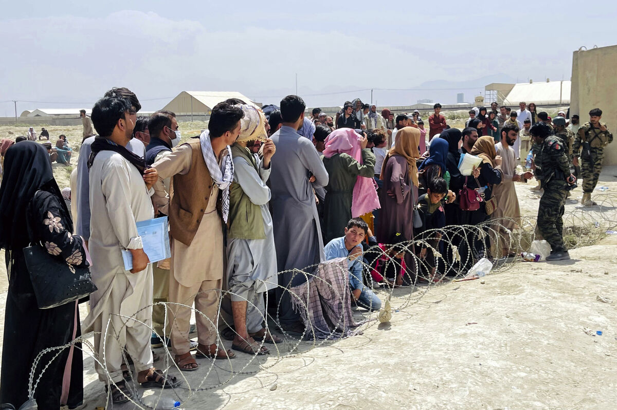 Afghan security guards try and maintain order as hundreds of people gather outside the international airport in Kabul, as desperate crowds tried to flee the country. Picture: AP 