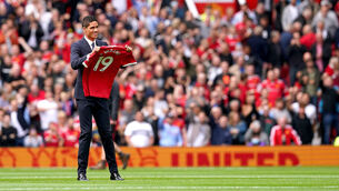 <p>Manchester United's Raphael Varane holds up his shirt on the pitch as is is confirmed that he has signed for the club. Picture: Martin Rickett/PA</p>