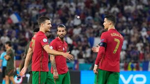 <p>Portugal's defender Joao Cancelo (L) shakes hands with Portugal's forward Cristiano Ronaldo at the end of the UEFA EURO 2020 Group F football match between Portugal and France at Puskas Arena in Budapest on June 23, 2021. (Photo by Darko Bandic / POOL / AFP) (Photo by DARKO BANDIC/POOL/AFP via Getty Images)</p>